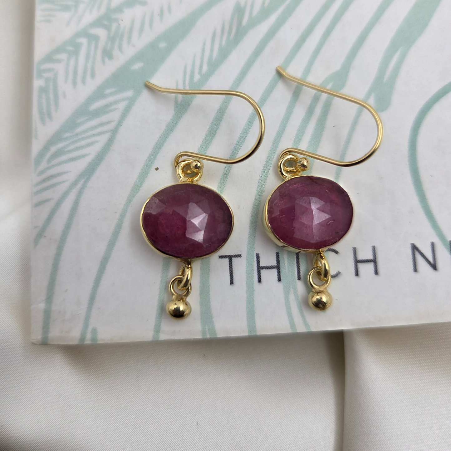 Silver earrings with ruby , 22 carat gold plated  with a drop on a book