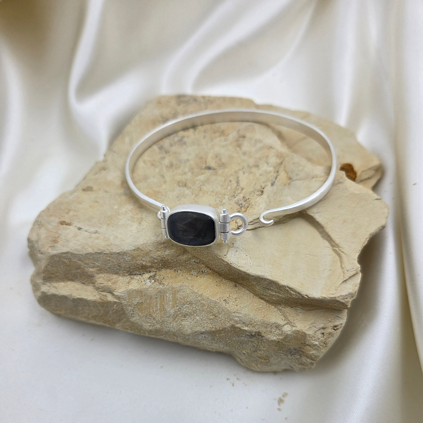 Silver bracelet with a blue stone flat