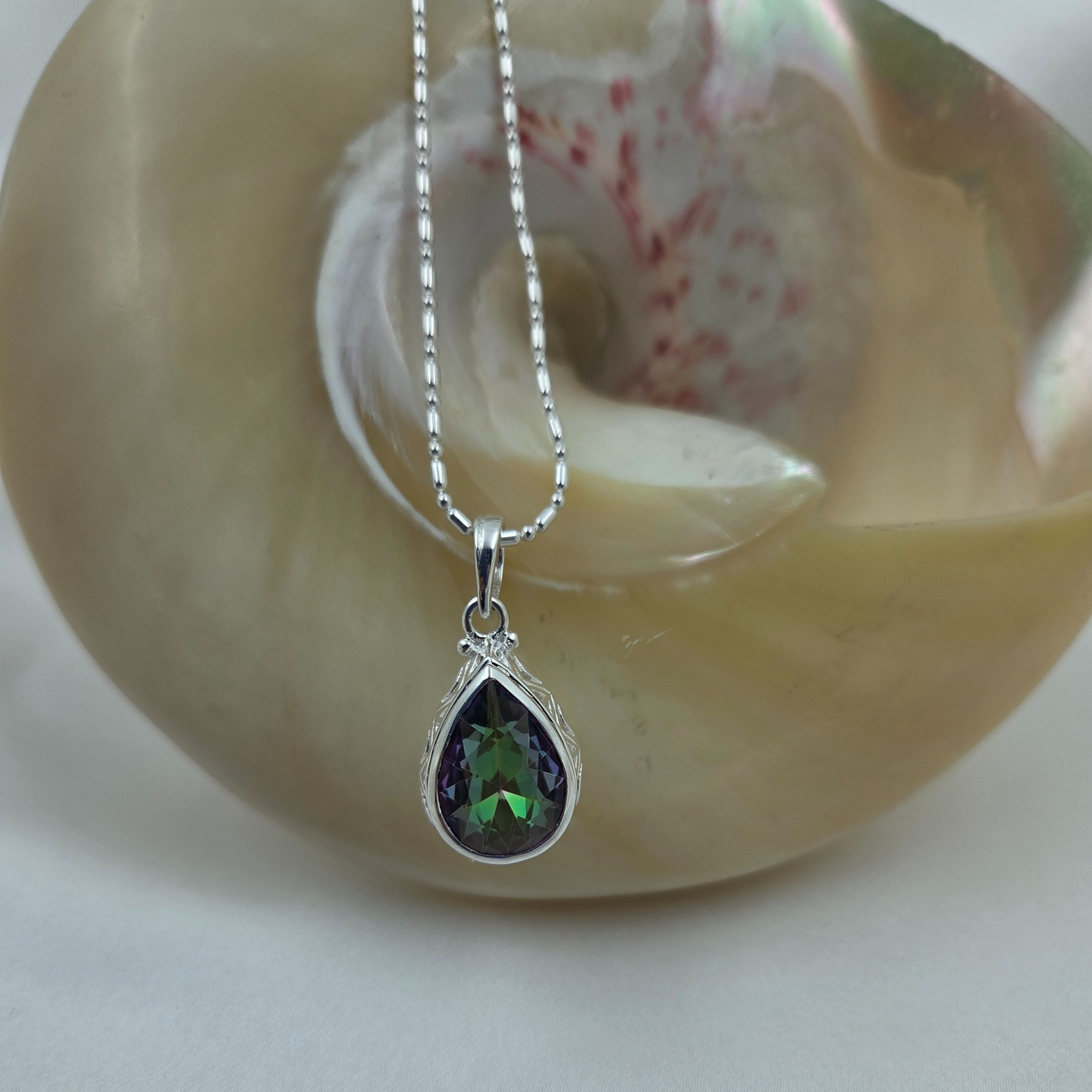 Silver necklace with a green and purple teardrop pendant 